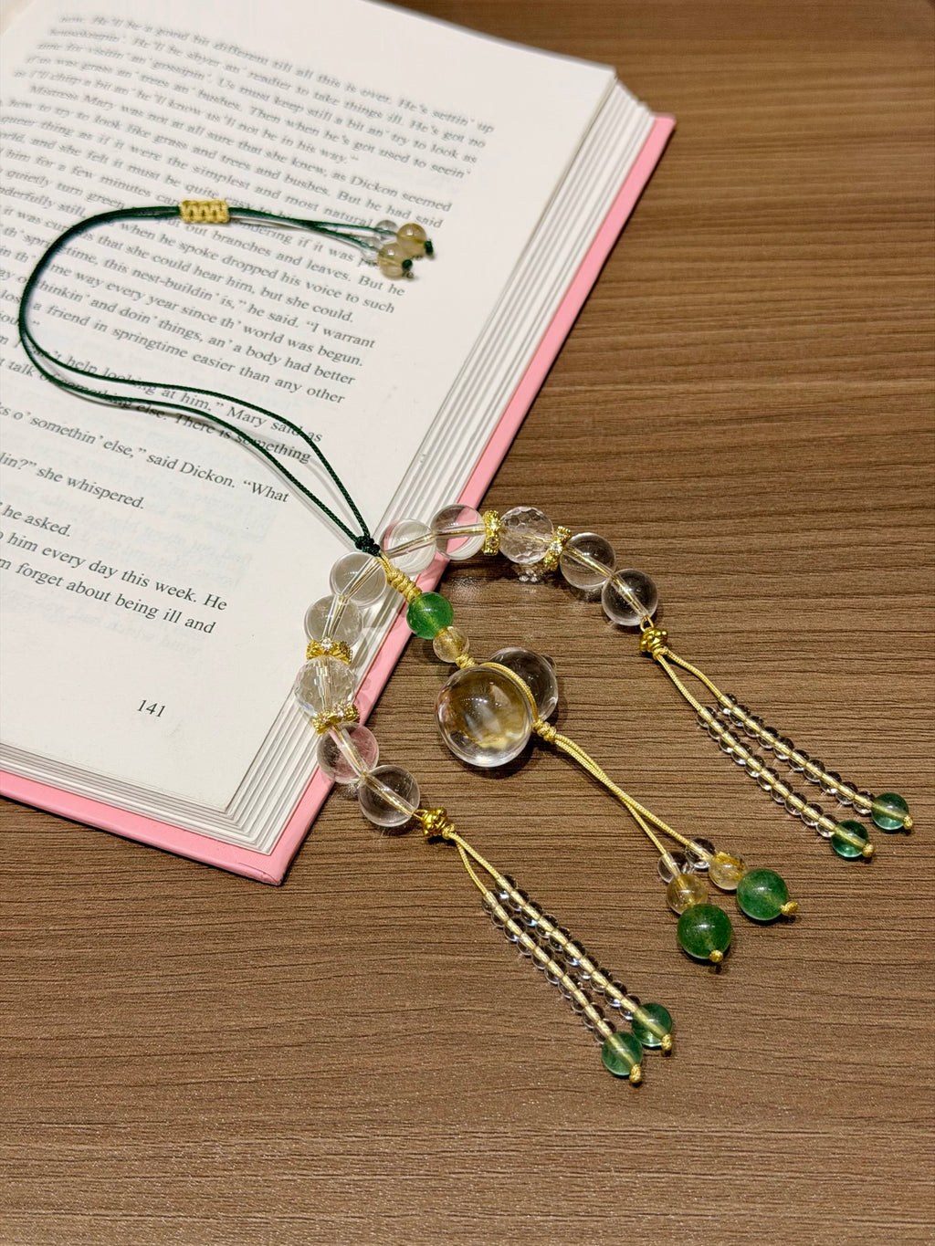 White crystal gourd car charm laid on open book