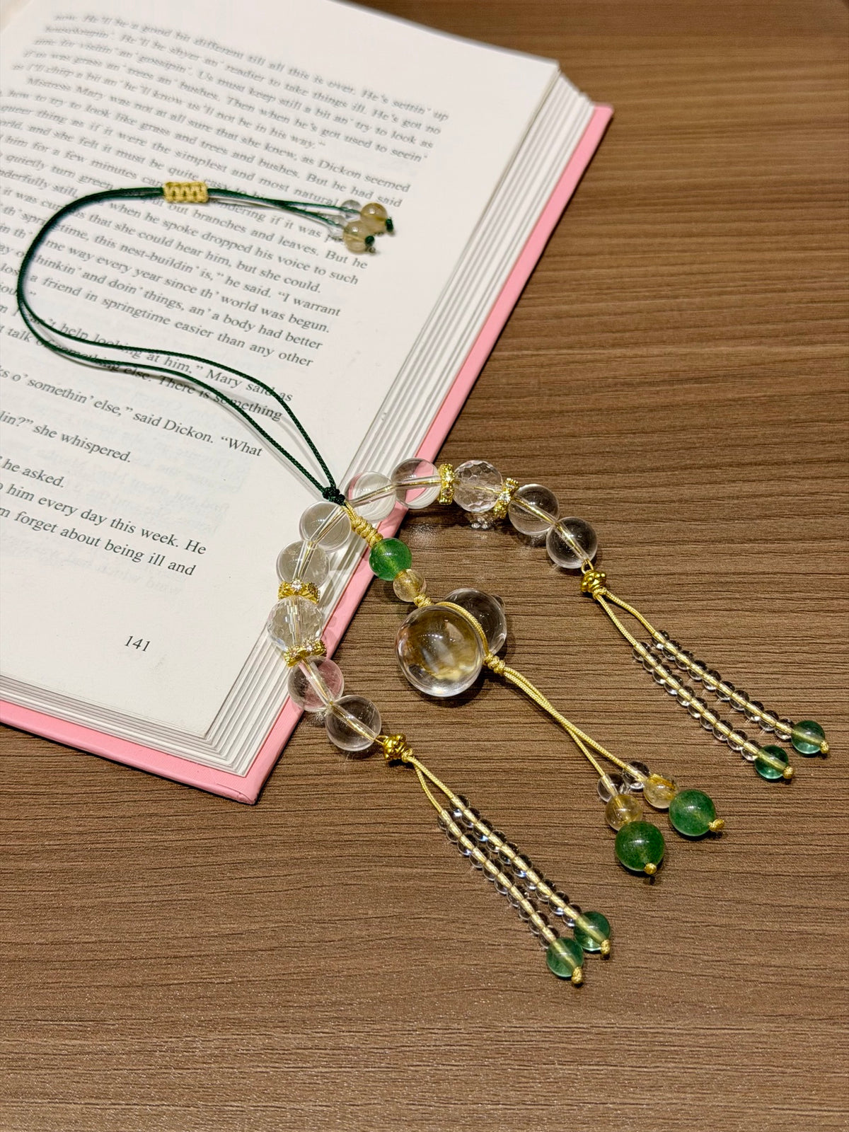 White crystal gourd car charm laid on open book