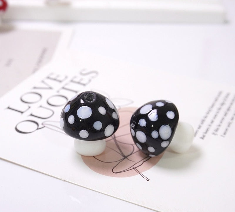 Pair of glossy black mushroom glass beads with white dots on LOVE QUOTES card
