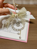 Starlight Dewdrop white crystal car hanging with gold bow held in hand
