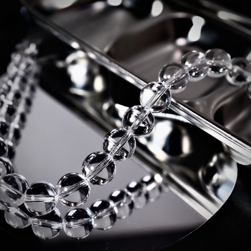 Clear crystal bead strand bracelet on reflective silver tray