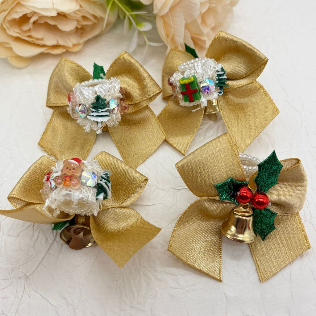 Four gold satin bow focal beads with lace trim, decorated with Christmas tree, gift, Santa, and bell charms.