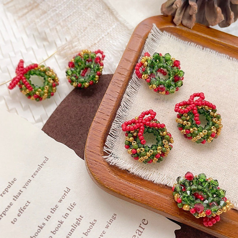 Small beaded Christmas wreath ornaments with red bows in red, green, and gold seed beads