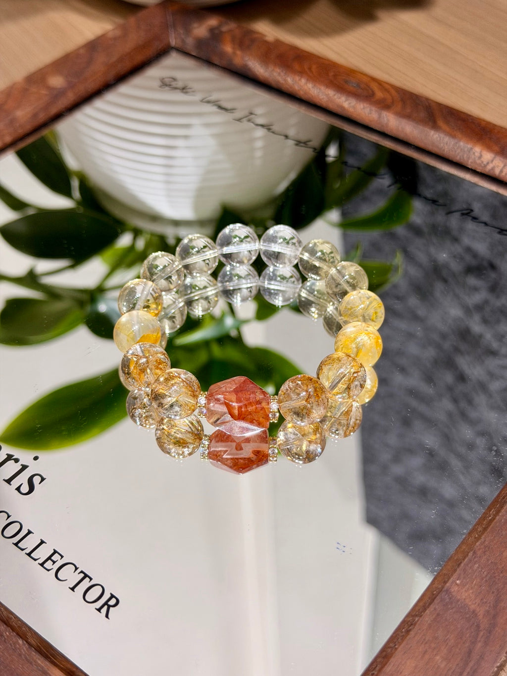 Golden hematoid quartz and citrine bracelet with red freeform bead worn on wrist