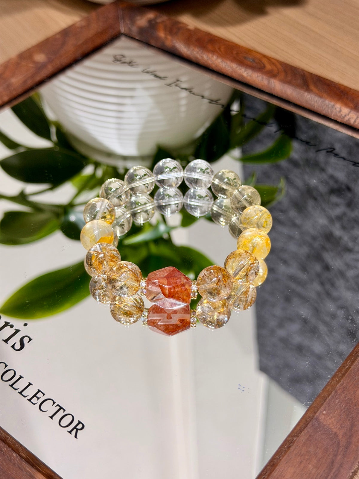 Golden hematoid quartz and citrine bracelet with red freeform bead worn on wrist