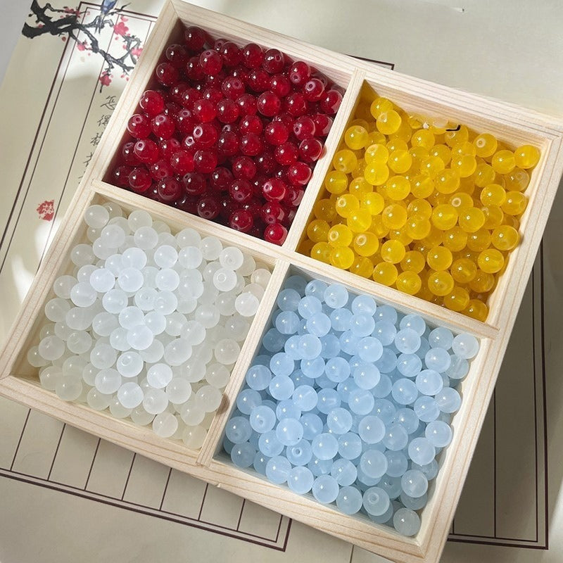 Wooden tray with four compartments of red, yellow, white, and blue round beads