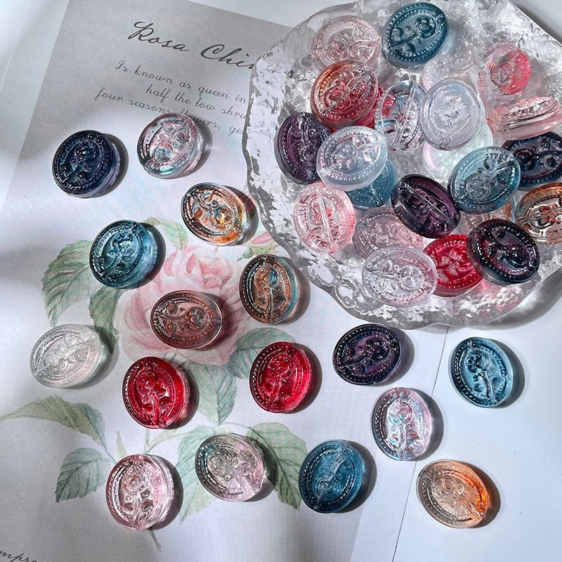 Colorful oval-shaped engraved glass rose beads displayed on white paper