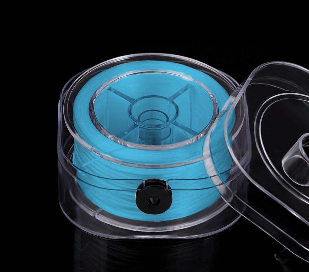 Bright blue elastic beading cord on a spool in a clear plastic protective case, lid partially visible, on black background