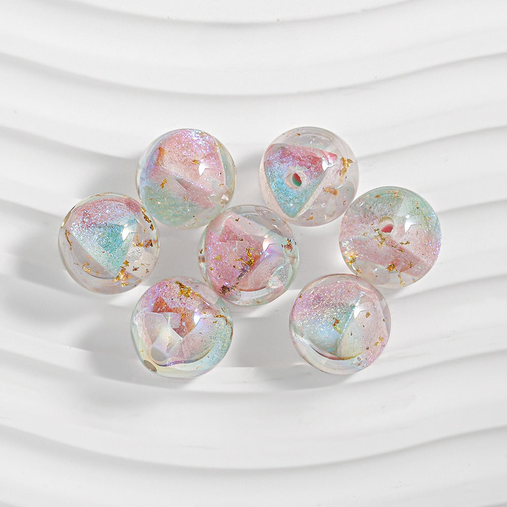 Seven clear resin beads with pastel iridescent swirls and gold foil