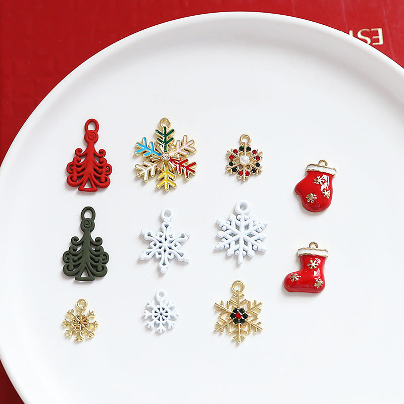 Set of Christmas-themed enamel charms on white plate, red and gold snowflakes
