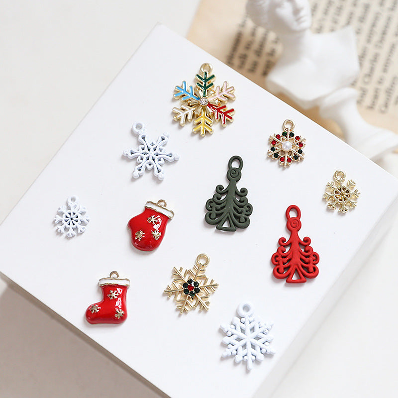 Set of small Christmas-themed jewelry charms on white card, snowflakes and stockings