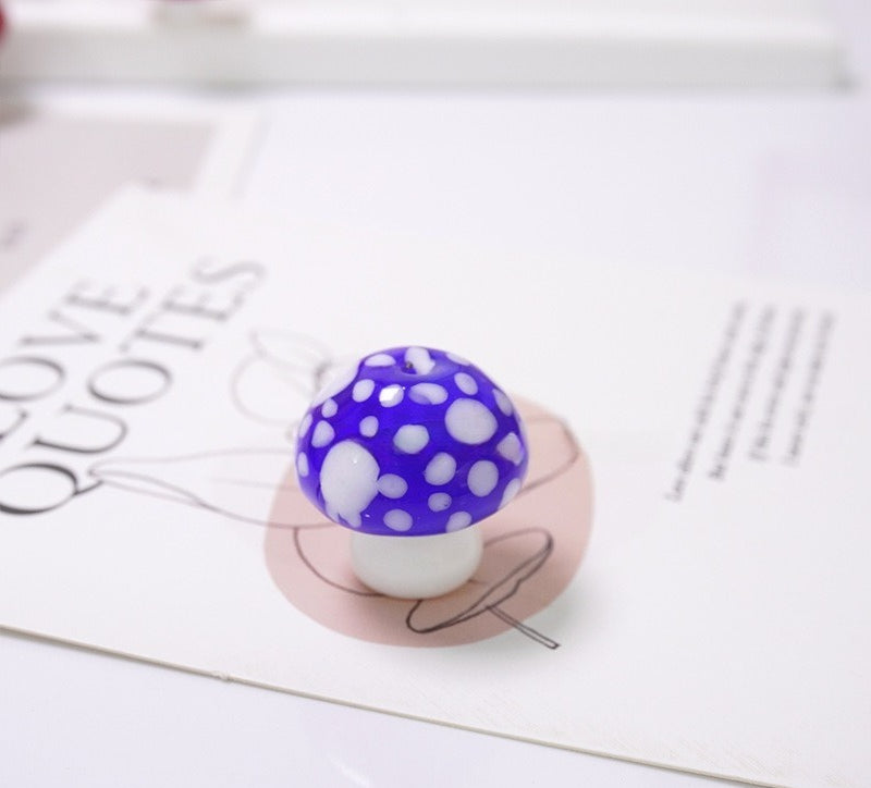 Purple mushroom-shaped glass bead with white spots on a LOVE QUOTES card