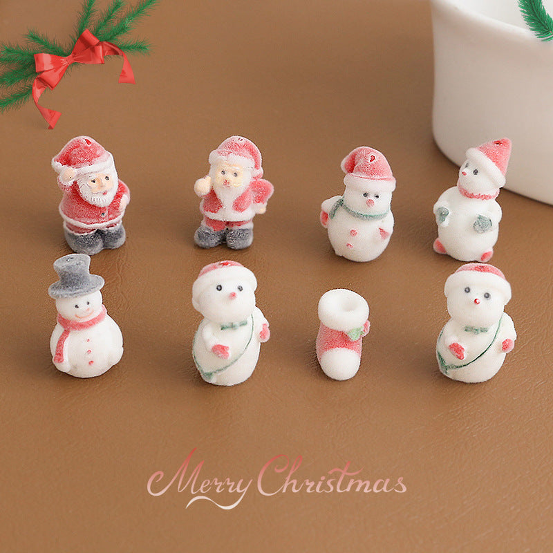 Eight small Christmas-themed figurines including Santa Claus and snowmen arranged on a brown surface