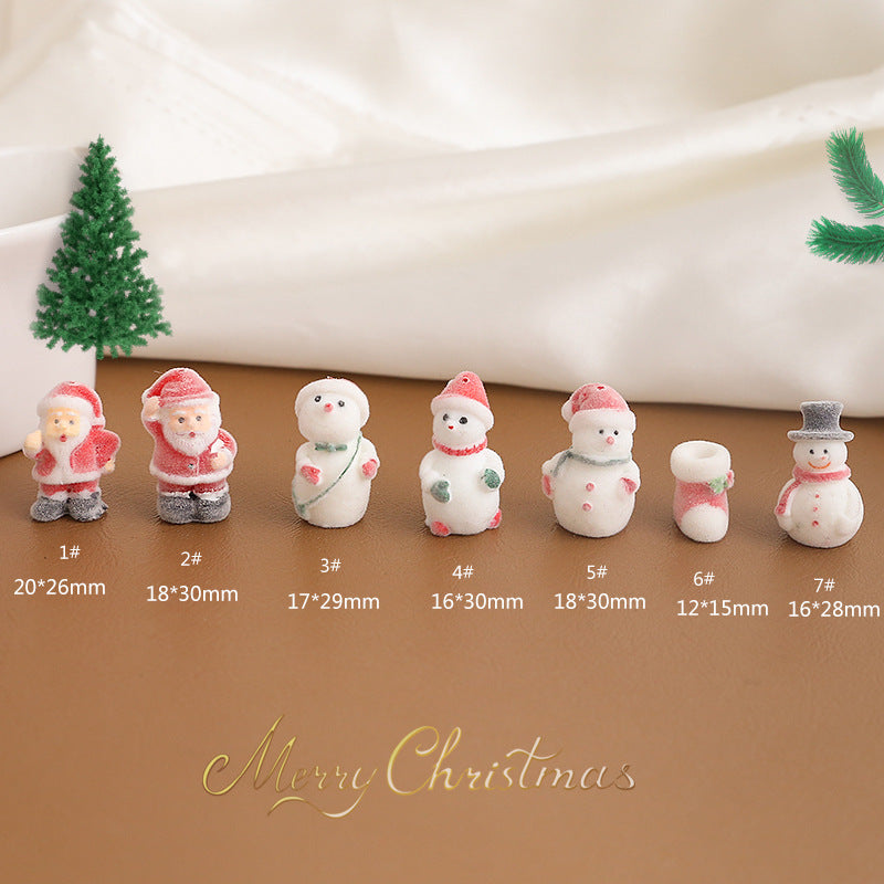 Seven small Christmas figurines and a stocking arranged in a row on brown surface