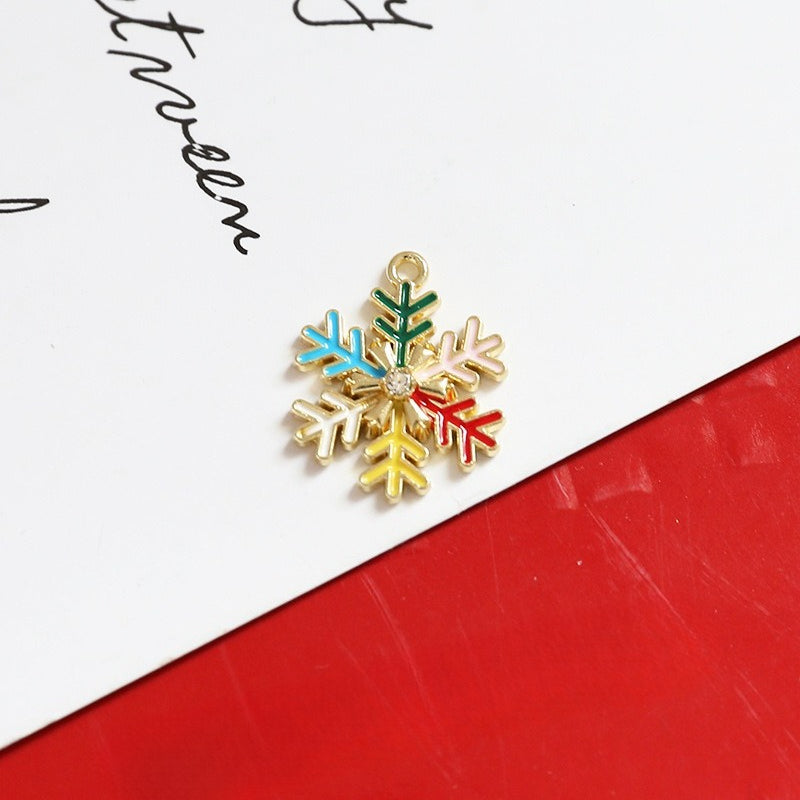 Gold snowflake charm with colorful enamel details in blue, green, pink, yellow and red
