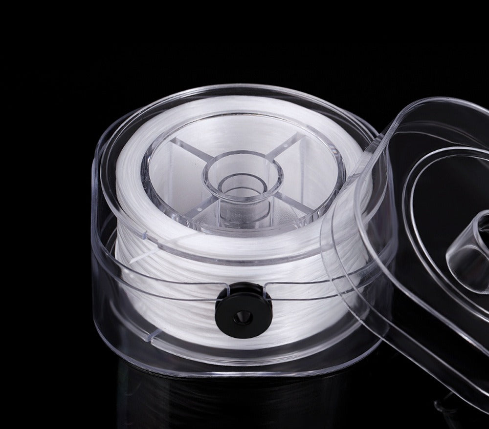Spool of white elastic beading cord in a clear plastic holder with transparent lid on black background