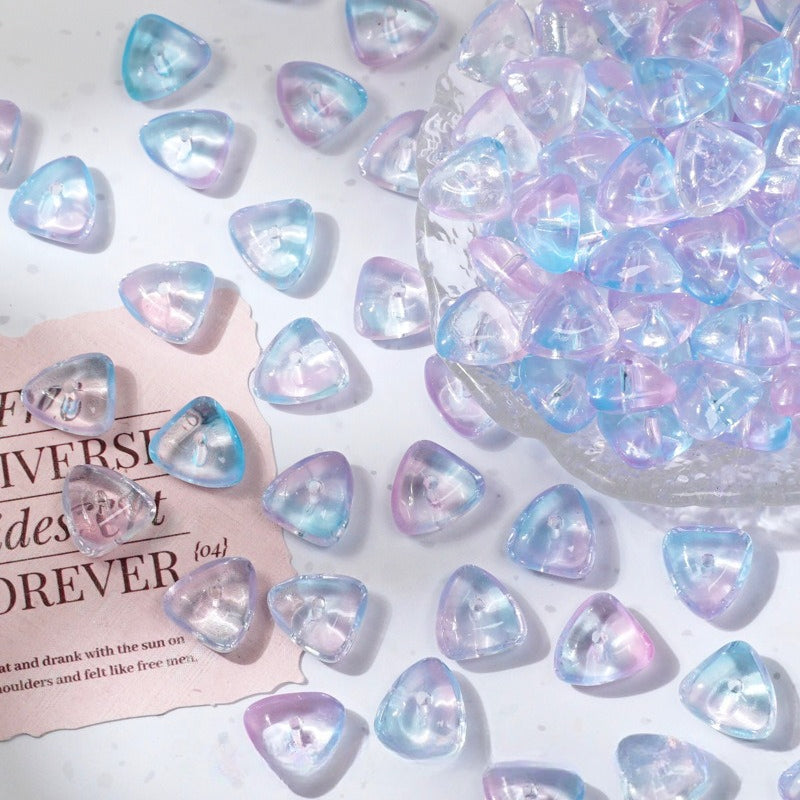 Heart-shaped translucent glass beads with pastel iridescent finish scattered on white