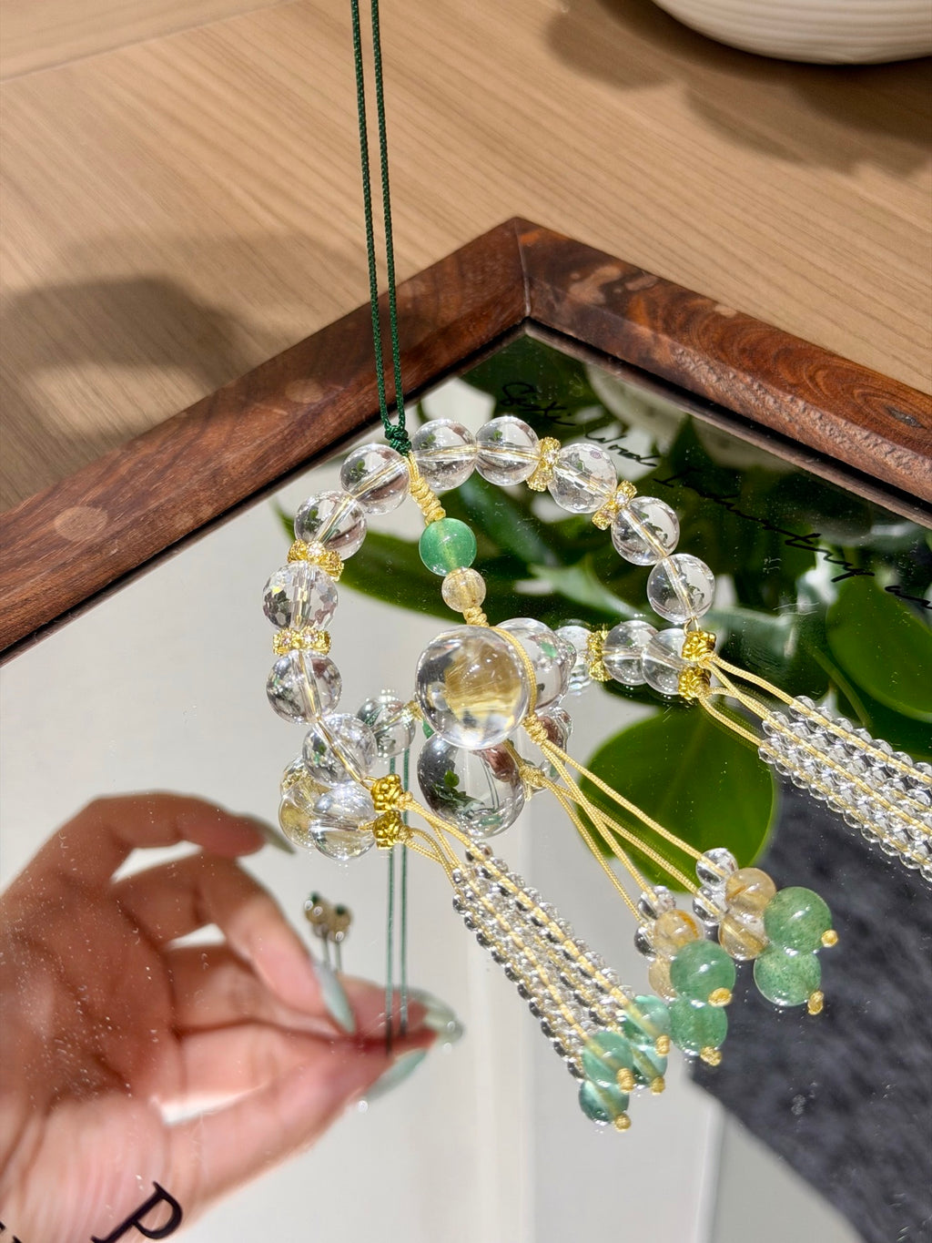 White crystal gourd car charm hanging over mirror tray
