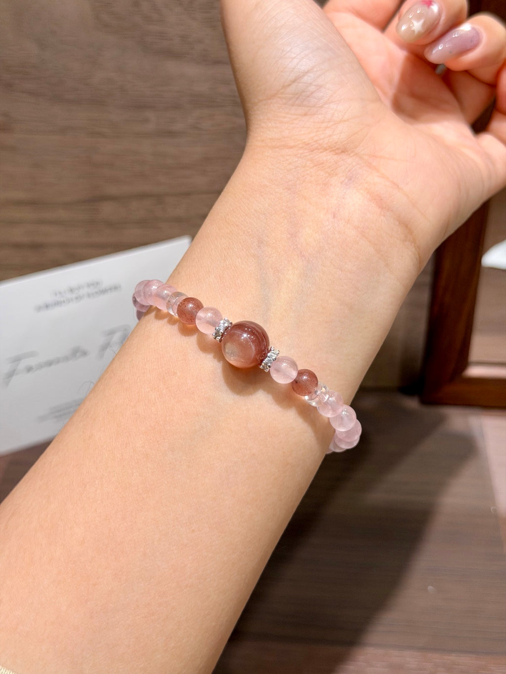 Pink gummy bracelet with pink lepidolite centerpiece worn on wrist
