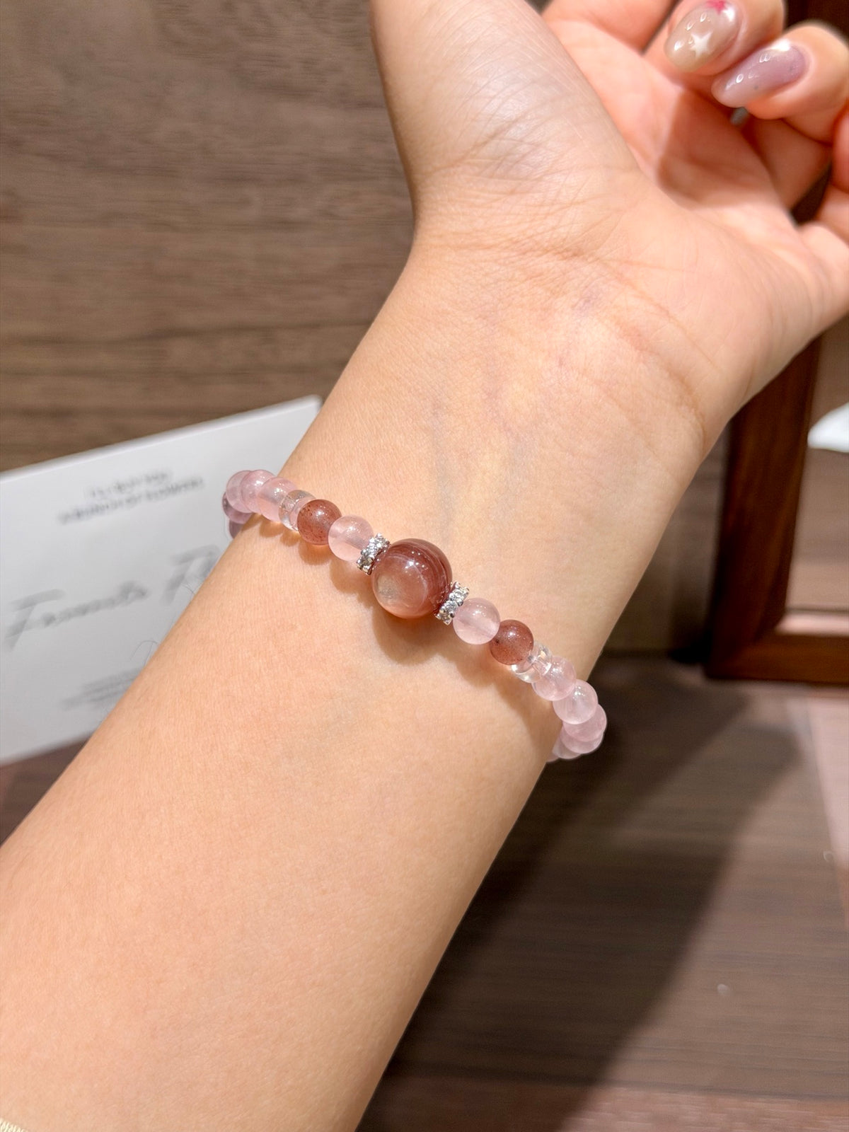 Pink gummy bracelet with pink lepidolite centerpiece worn on wrist
