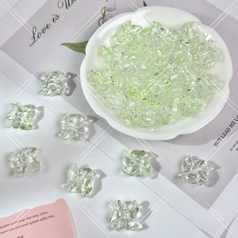 Crystal mint green 20mm carved glass windmill beads on a white surface with a white bowl and white dish