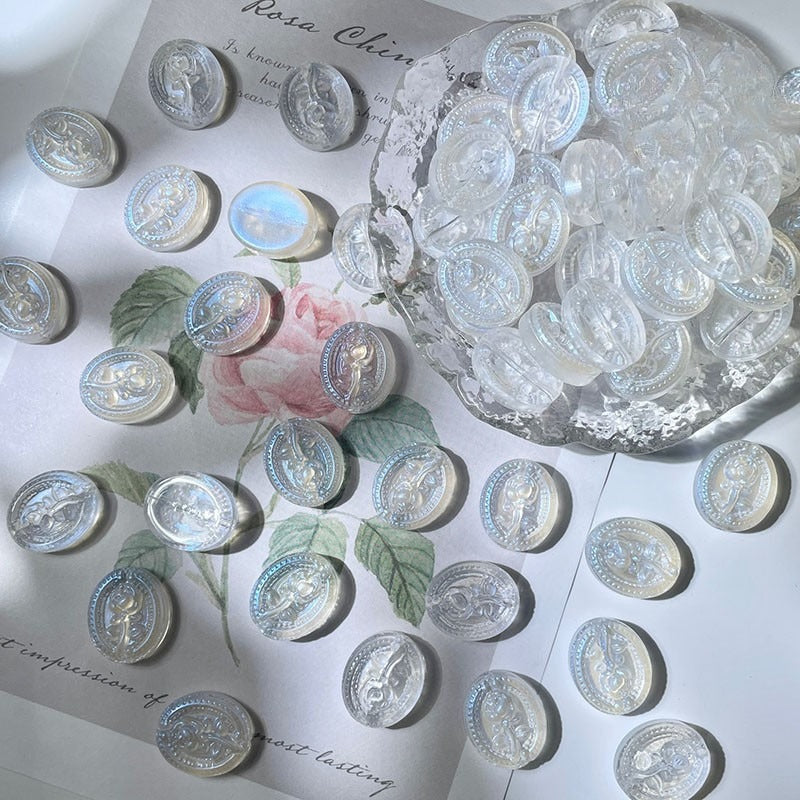 Round clear iridescent engraved glass beads in a bowl and scattered