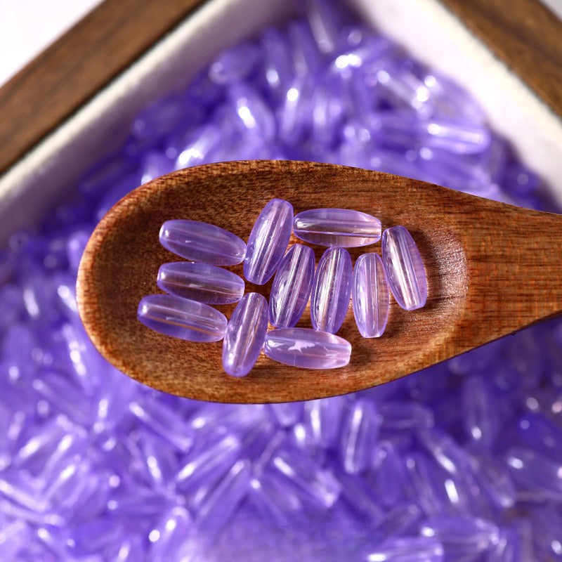 Purple 4x9mm glazed glass long rice beads in a wooden spoon