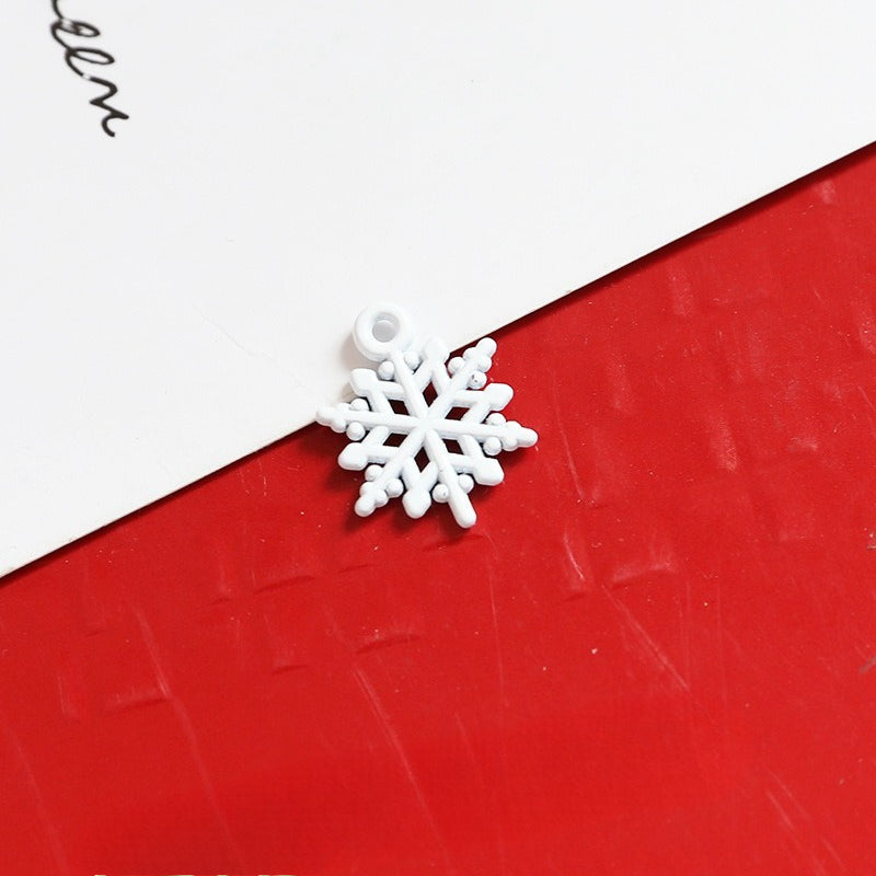 Small white snowflake-shaped charm with loop on diagonal split background