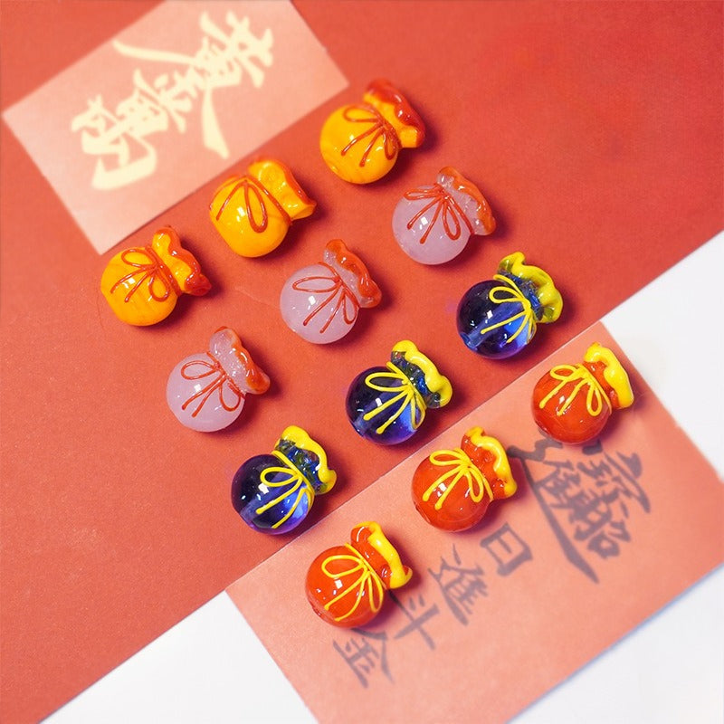 Thirteen colorful glass lucky bag beads arranged on red paper with calligraphy.