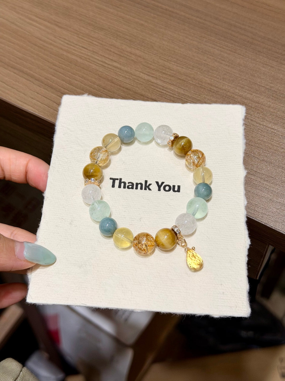 Gilded Dawn bracelet with blue water jade, fluorite, citrine and tiger's eye beads reflected in mirror