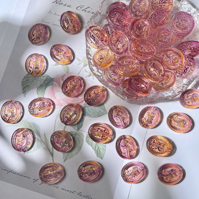 Round engraved glass rose beads with embossed designs on white floral paper