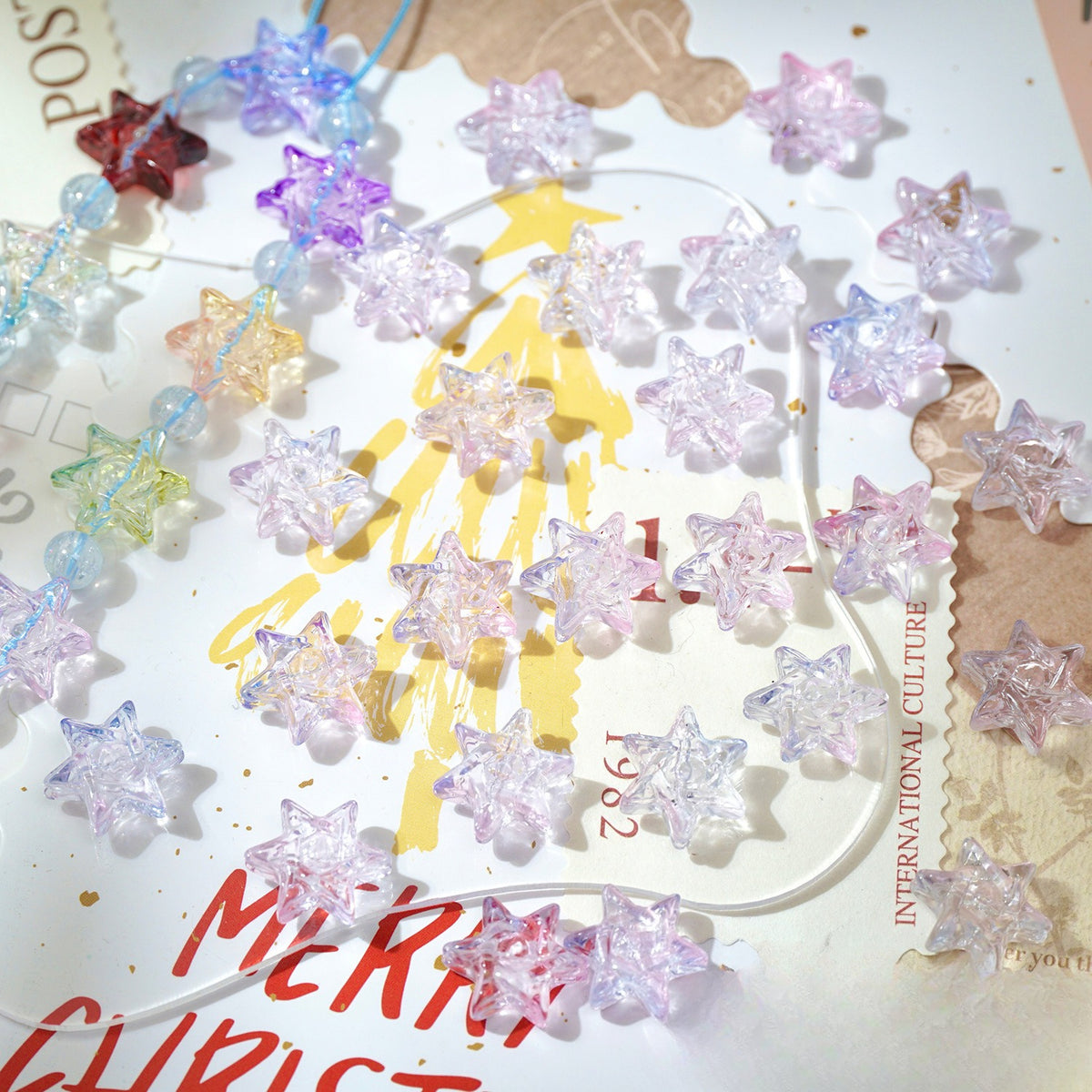Clear glittery star-shaped glass beads scattered on a decorated Christmas card