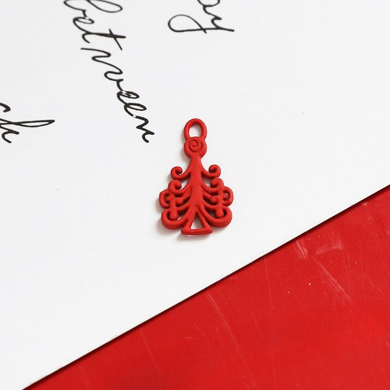 Small red decorative tree-shaped charm with ornate scroll design and loop