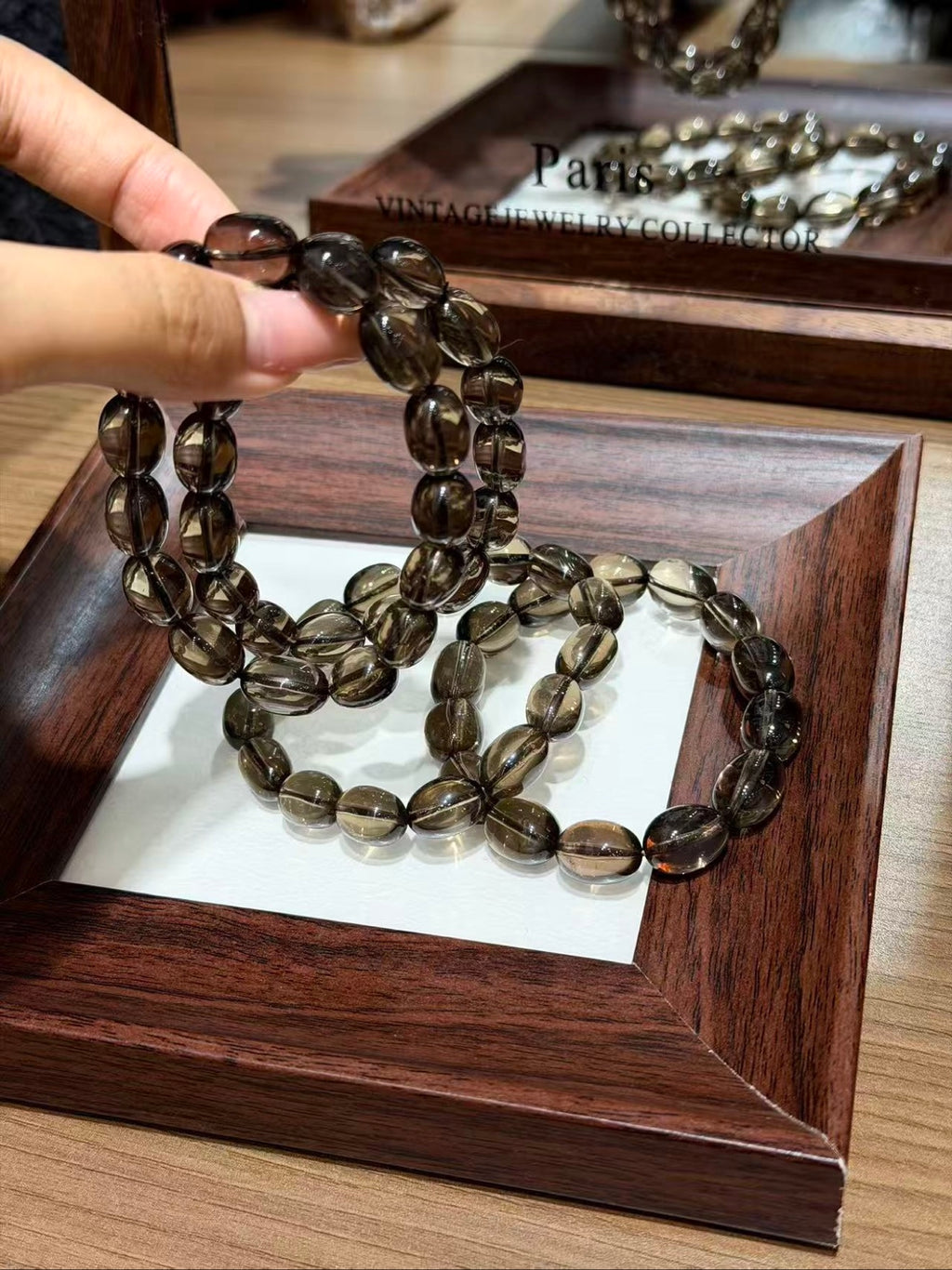 Hand holding a smoky quartz jelly bean bracelet strand