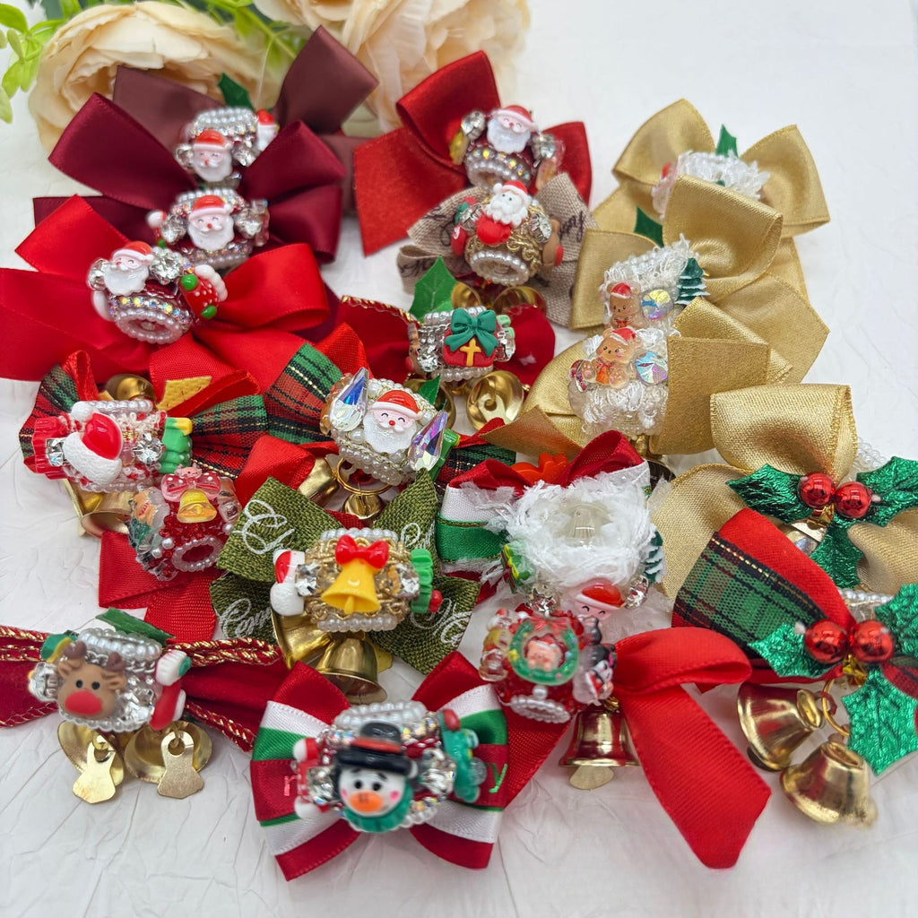 Pile of Christmas bow focal beads with red and gold satin bows, Santa and snowman figures, jingle bells, and rhinestones.