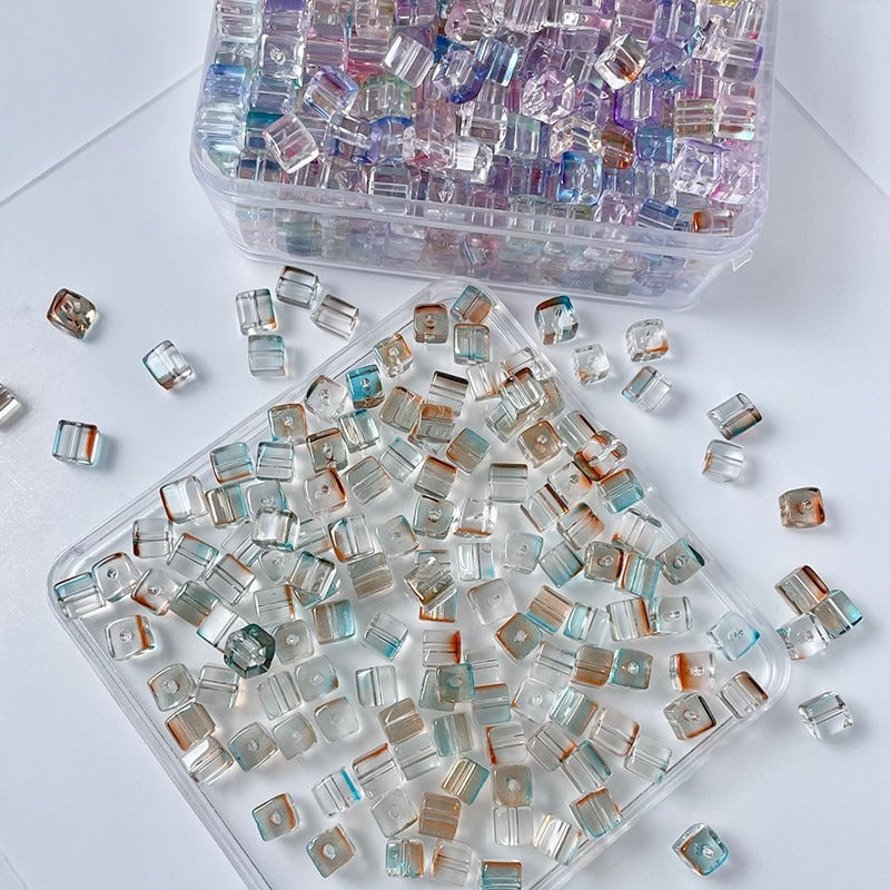Clear square glass beads with iridescent pastel reflections in two trays