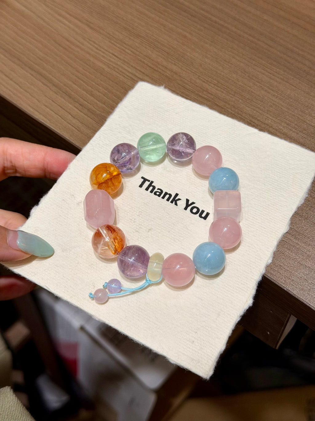 Spring Candy Jar chunky pastel crystal bracelet held in hand over open book