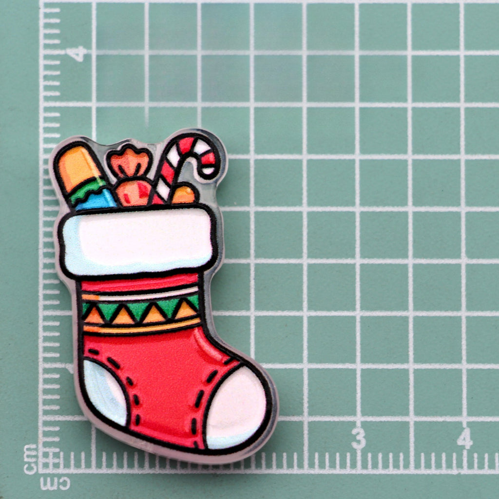 Christmas stocking acrylic charm filled with candy and candy canes on green cutting mat