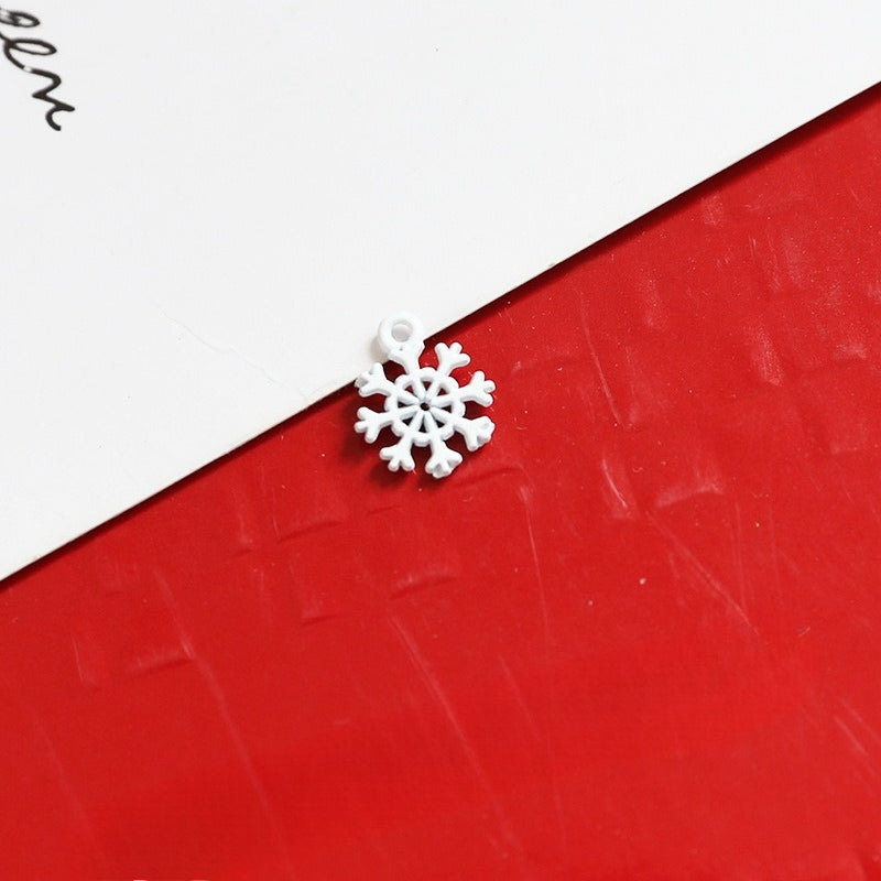 Small white snowflake-shaped jewelry charm with hanging loop