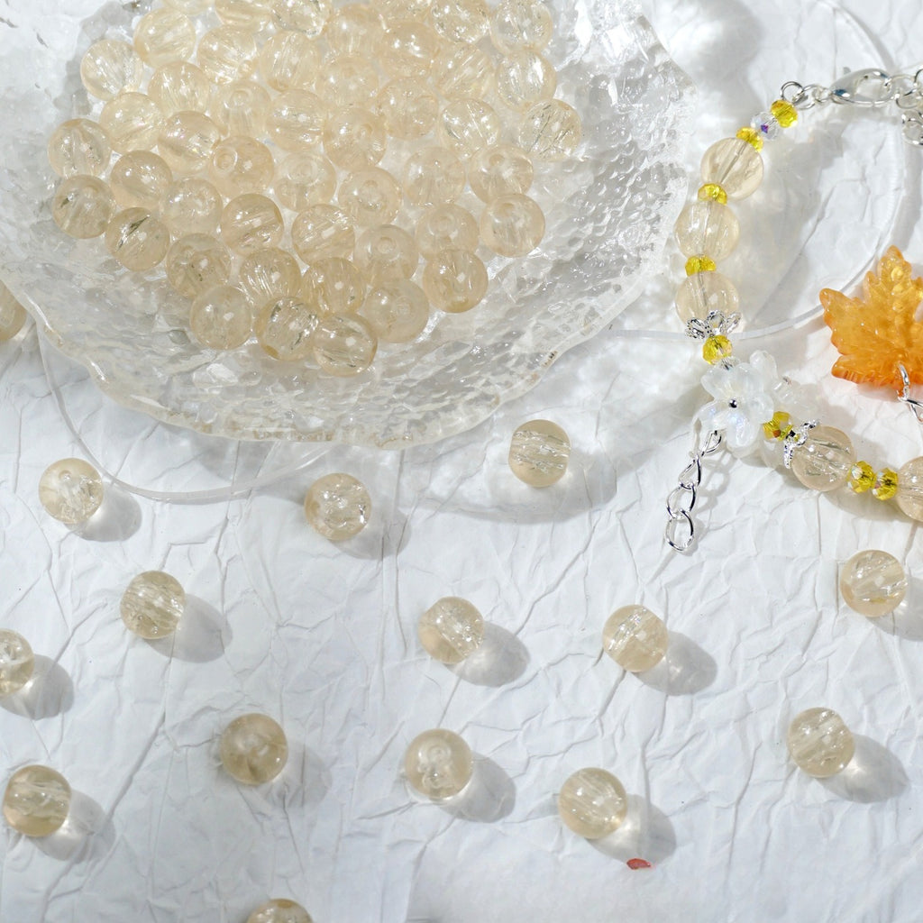 Champagne glass bead bracelet beside a bowl of loose champagne beads