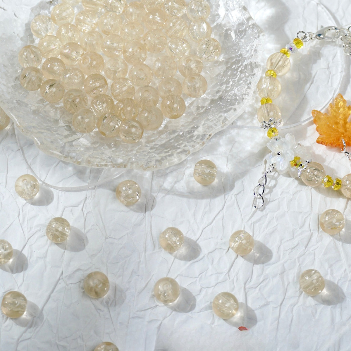 Champagne glass bead bracelet beside a bowl of loose champagne beads