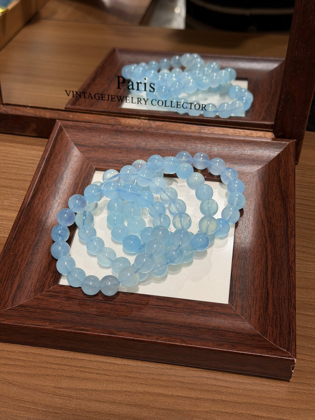 Premium aquamarine bracelet coiled on mirror tray