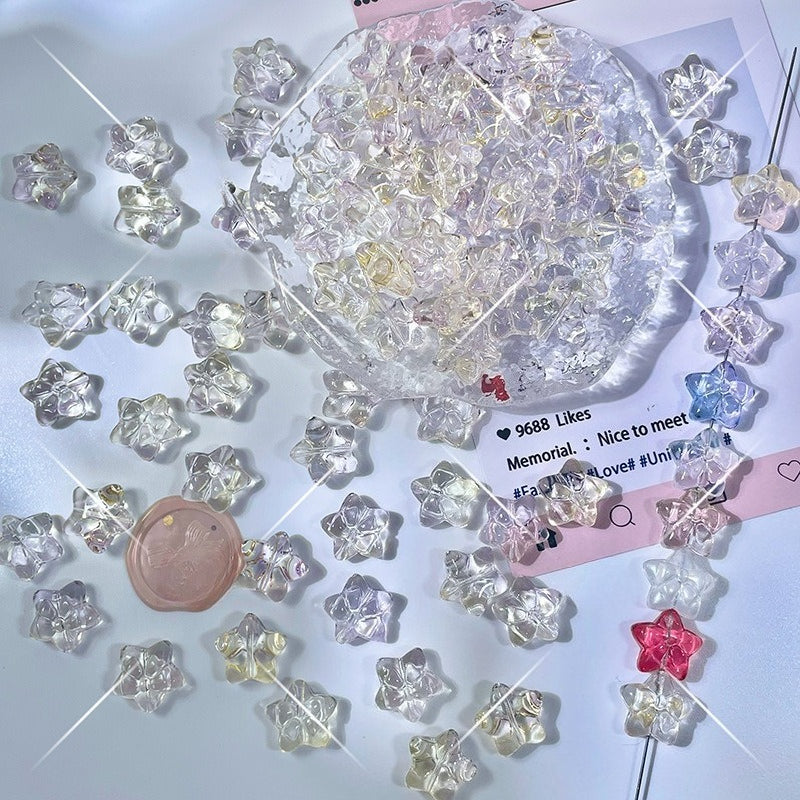 Clear star-shaped glass beads with a pink wax seal charm on a white surface