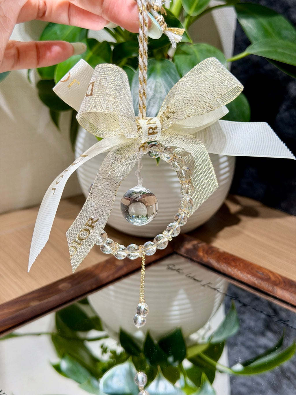 Starlight Dewdrop car charm with faceted white crystal beads and gold ribbon bow over open book