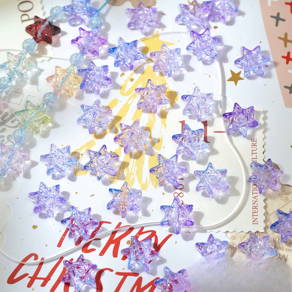 Translucent star-shaped glass beads in pastel purple, blue, pink, and yellow on white