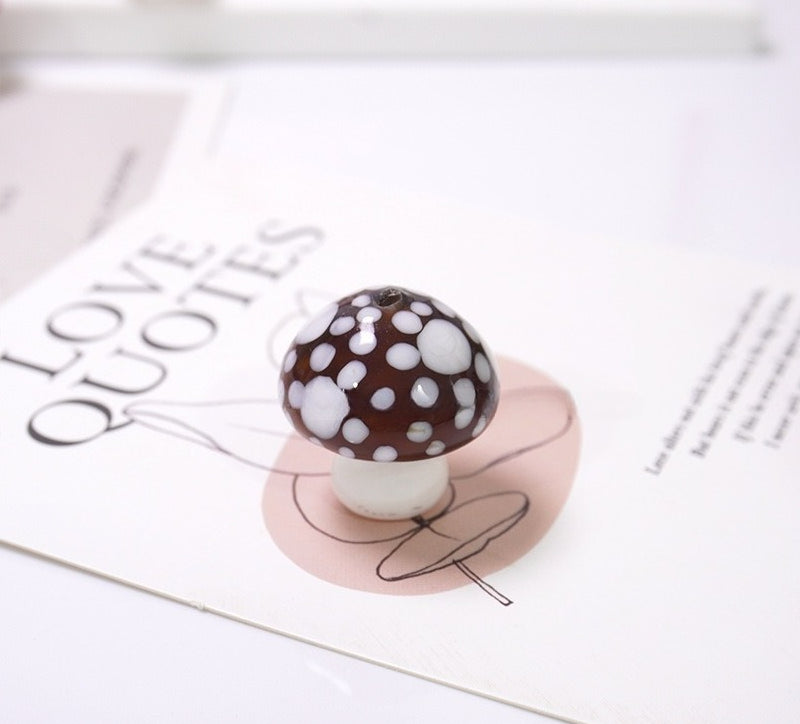 Brown mushroom-shaped glass bead with white spots on a LOVE QUOTES card