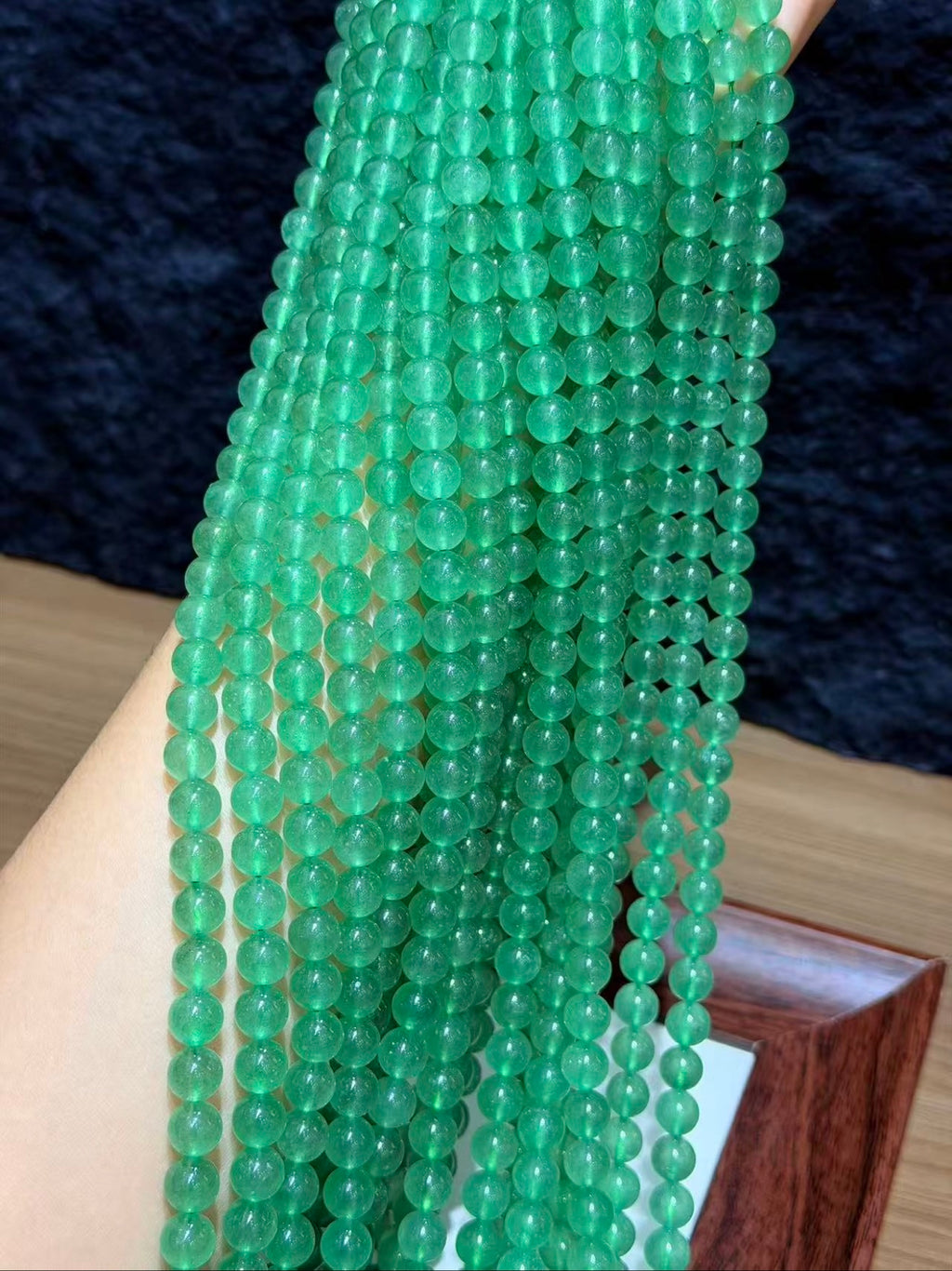 Green strawberry quartz bead strands laid on a Thank You card