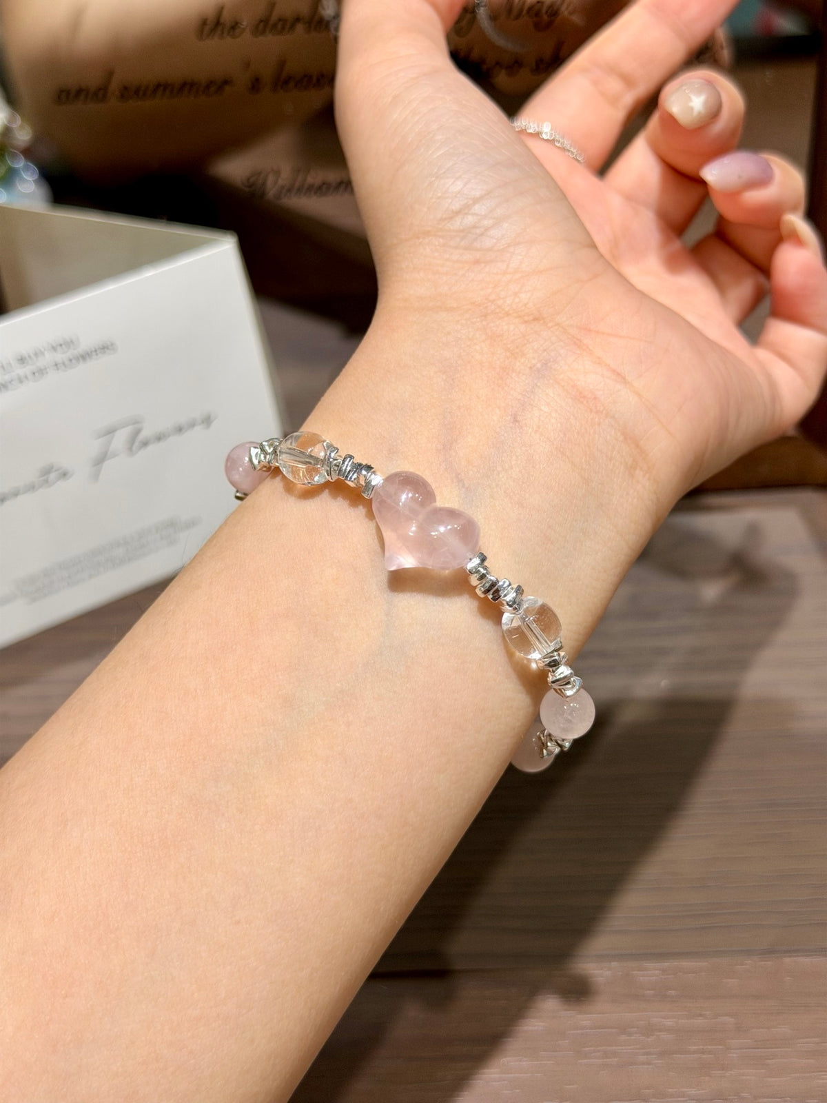 Pink heart quartz bracelet with pink quartz heart laid on table