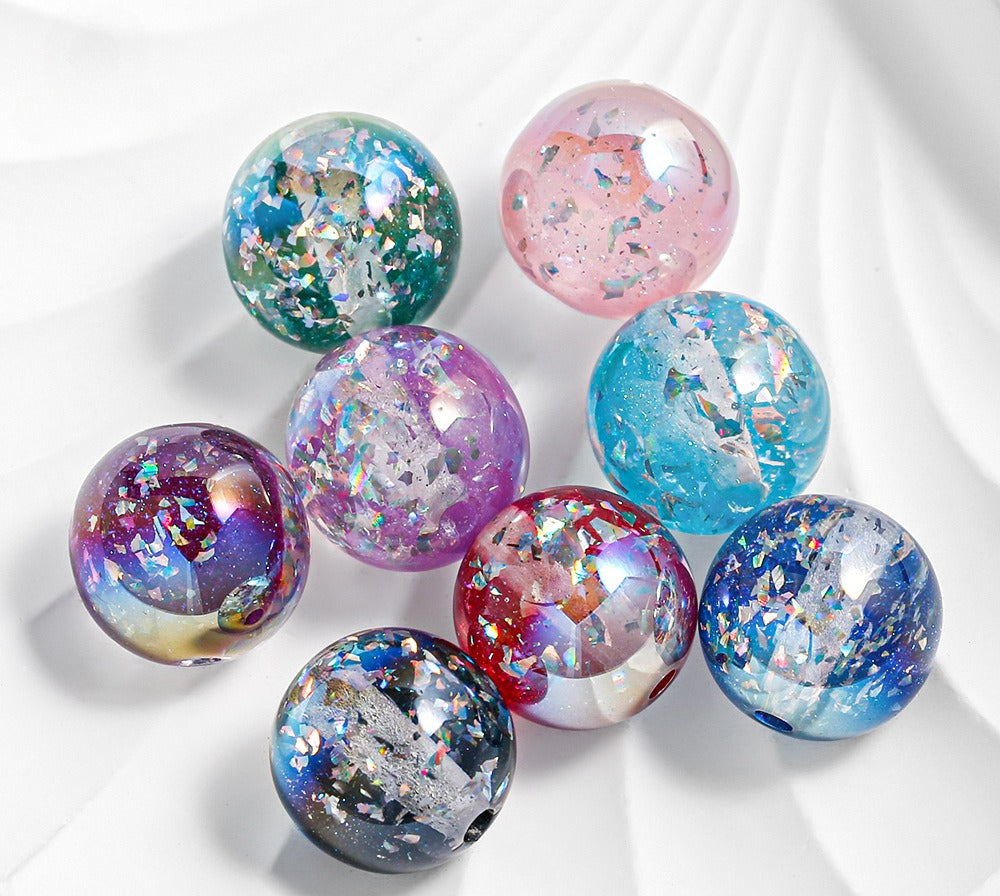 Eight round two-tone gradient resin beads with iridescent glitter on a white background