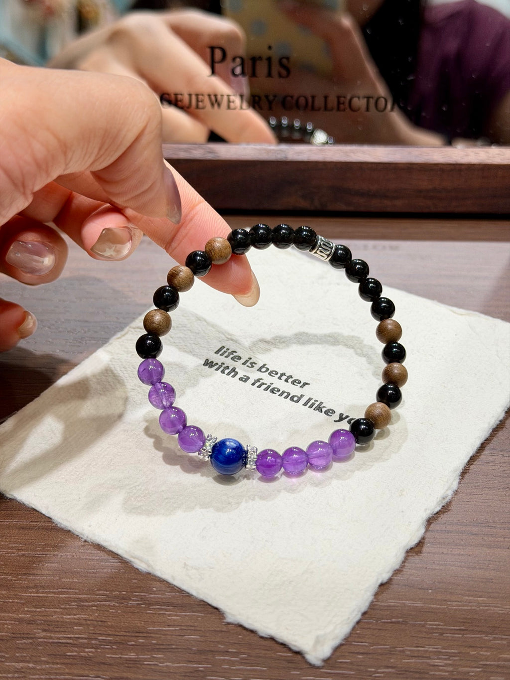 Hand holding dusk mountain bracelet with blue kyanite centerpiece